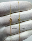 Two 10k solid gold rope chain strands displayed on a white textured glove, showing clasp details with overlaid measurements '0.8mm' and '1mm'.