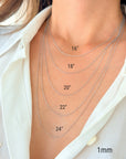 Five 14k solid white gold twisted rope chains of different lengths, 16 inches, 18 inches, 20 inches, 22 inches, and 24 inches, are layered on a model's neck. The chains are all the same width, 1mm.
