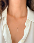 Model wearing a 10K or 14K yellow gold cross pendant necklace with a matching gold rope chain