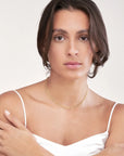 Close-up of layered beaded 14K gold necklace on model