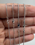 Four round 14K white gold round box chains of varying thicknesses 1.3mm, 1.8mm, 2.1mm, 2.7mm held in hand against a neutral background.