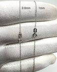 Two 10k white solid gold rope chain necklaces displayed on a white textured fabric background, labeled with measurements 0.8mm and 1mm to show chain width differences.