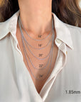 A close-up of a person's neck and upper chest wearing layered 14K white gold Miami Cuban Curb chain necklaces, with printed size labels showing 16", 18", 20", 22", 24", and 1.85mm.