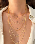 A close-up of a person's neck and upper chest wearing multiple layered gold snake chain necklaces, with printed size labels reading 16", 18", 20", 22", and 24" overlaid on the image.