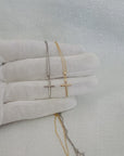 Video showing 10K or 14K yellow and white gold classic cross pendant necklaces with matching twisted rope chains with spring ring clasps displayed on a white-gloved hand.